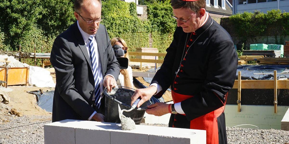 Der Kölner Erzbischof Rainer Maria Kardinal Woelki und Projektleiter Dr. Martin Günnewig legen den Grundstein für das integrative Wohnprojekt am Klarissenkloster in Köln-Kalk.