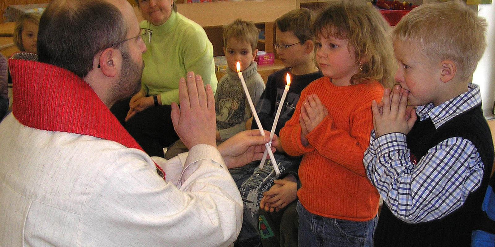 Priester spendet Kindern den Blasius-Segen