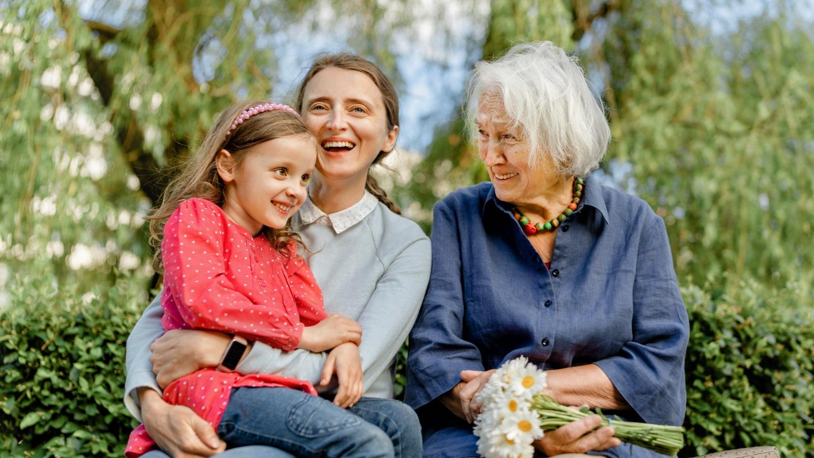 happy laughing people of different generations in the park on a bench. Joyful meetings of family members
