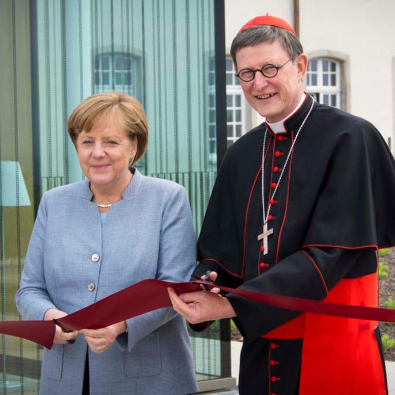 Angela Merkel und Rainer Woelki durchschneiden das Band zur Eröffnung des KSI