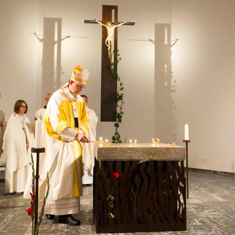 Kardinal Woelki entzündet auf dem Altar die Wachsdochte mit Weihrauch