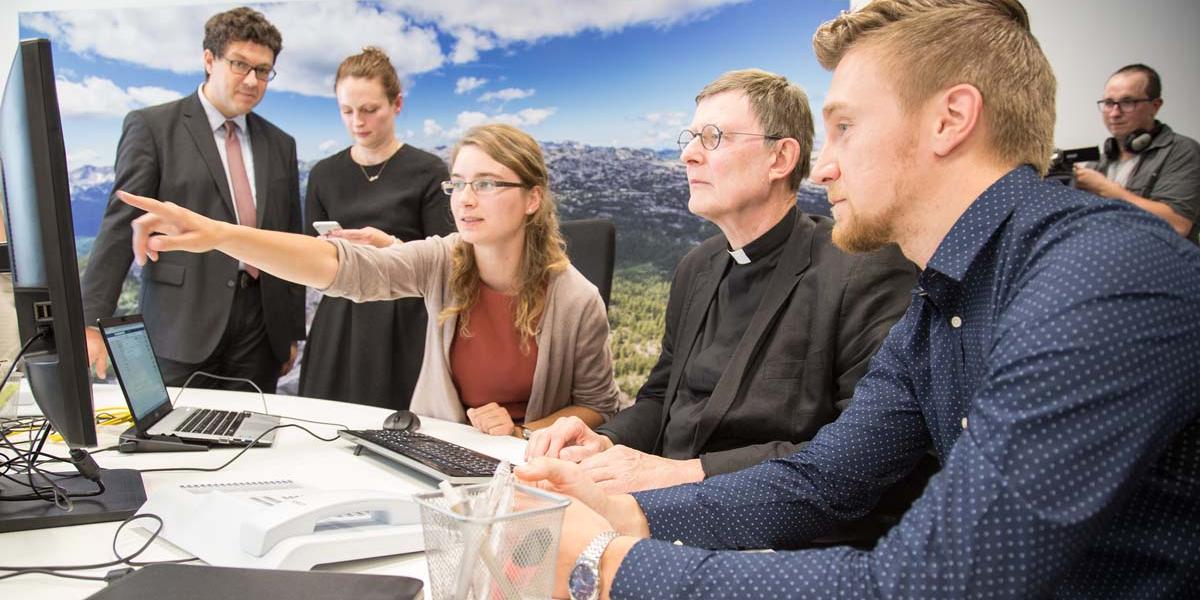 Gemeinsam mit dem Social Media Team bereitet Kardinal Woelki einen Facebook-Post vor.