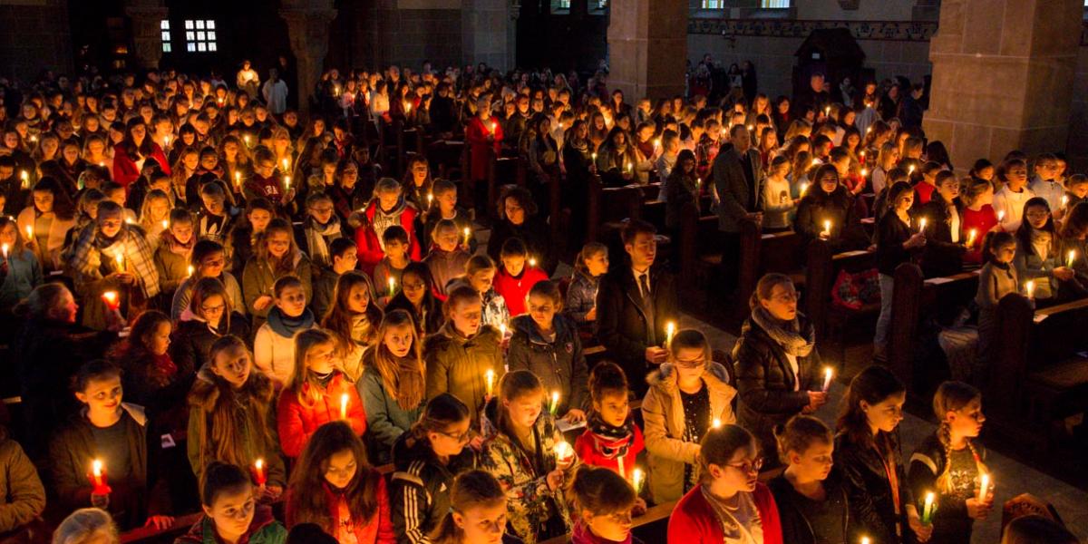 Nur von Kerzen erleuchtet beginnt der Festgottesdienst der Liebfrauenschule in St. Elisabeth Bonn