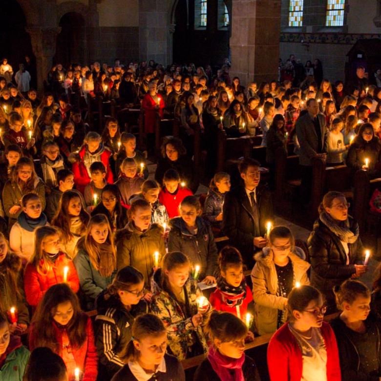 Nur von Kerzen erleuchtet beginnt der Festgottesdienst der Liebfrauenschule in St. Elisabeth Bonn