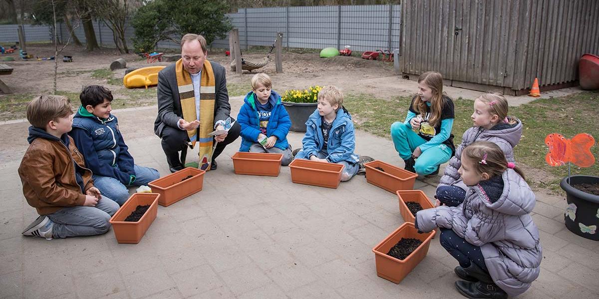 Stadtdechant Monsignore Robert Kleine erklärt den Kommunionkindern aus Köln und Oberberg das Symbol des Schmetterlings