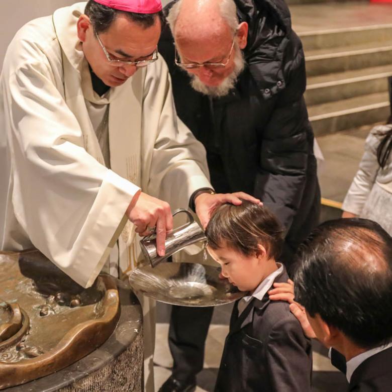 Erzbischof Kikuchi tauft den dreijährigen Akihito auf den Taufnamen Franzisko Xaver.