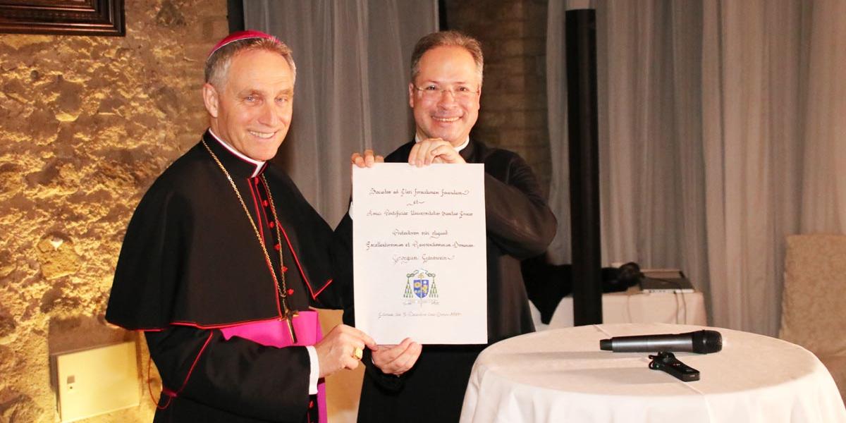 Erzbischof Georg Gänswein erhält vom Vorsitzenden Stefan Mückl die Urkunde