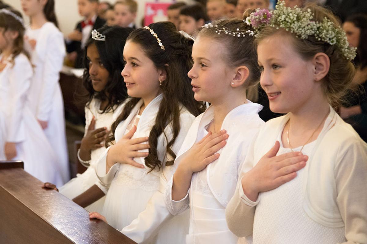 Kommunionkinder während der Feier der Erstkommunion in der Kirche St. Pankratius in Köln-Worringen
