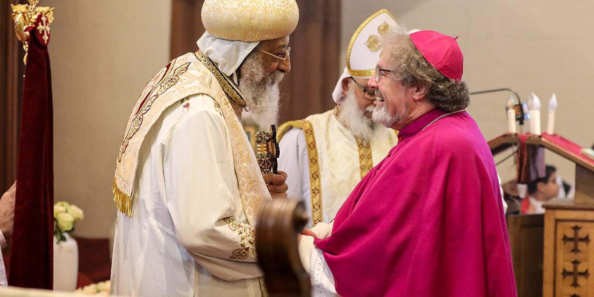 Der koptische Papst Tawadros II. (links) bedankt sich bei Weihbischof Rolf Steinhäuser für die Schenkung der Bunkerkirche