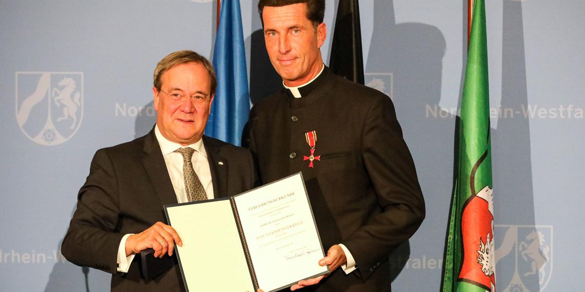 Ministerpräsident Armin Laschet übergibt Stadtdechant Dr. Wolfgang Picken das Verdienstkreuz am Bande