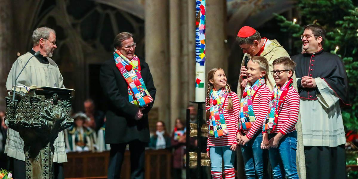 Kardinal Woelki im Gespräch mit dem designierten Kinderdreigestirn an der Karnevalskerze