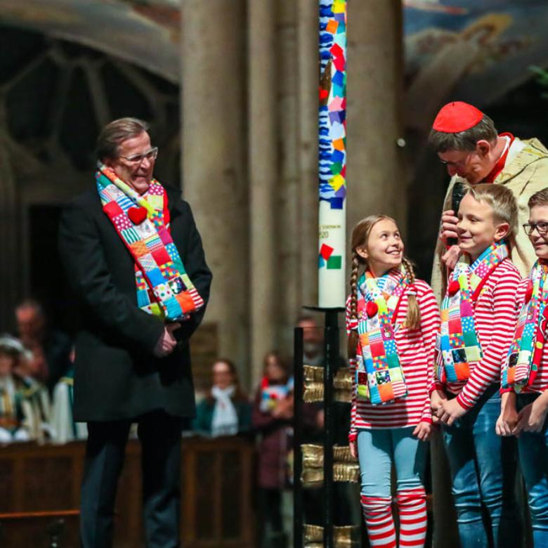 Kardinal Woelki im Gespräch mit dem designierten Kinderdreigestirn an der Karnevalskerze