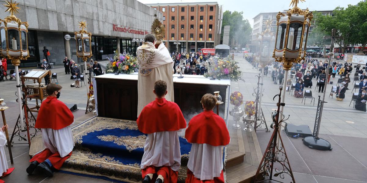 Mit der gewandelten Hostie, die in die Monstranz eingesetzt wurde, segnet Kardinal Woelki die Gottesdienstteilnehmer