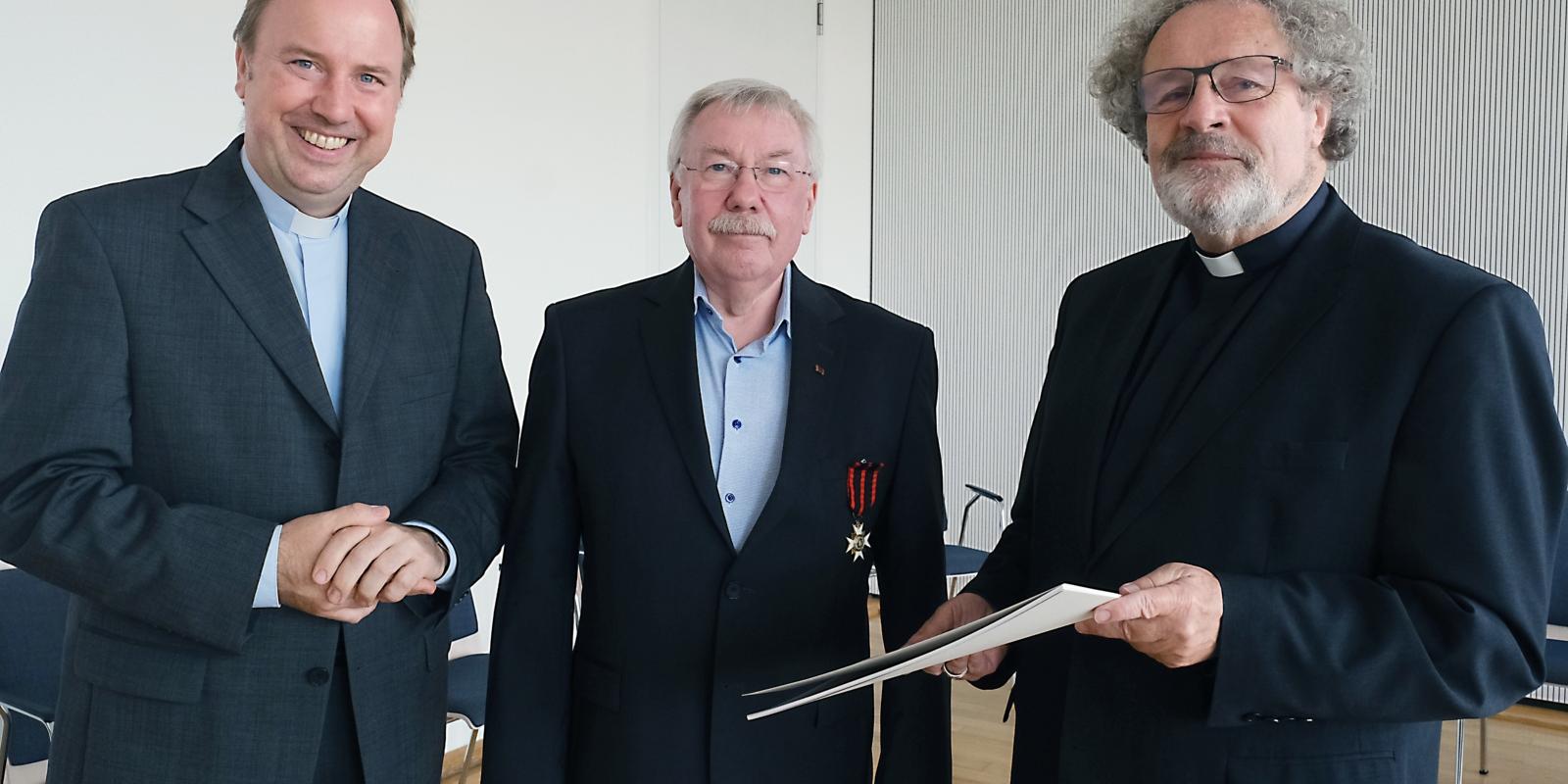 Der Kölner Stadtdechant Robert Kleine (links) und Weihbischof Rolf Steinhäuser (rechts) mit dem Träger des Silvesterordens Günter Kühler (Mitte) Weihbischof Rolf Steinhäuser und Stadtdechant Robert Kleine überreichen den Silvesterorden an Günter Kühler