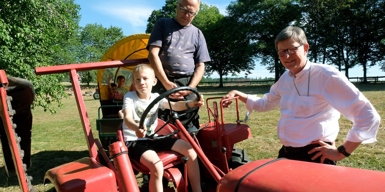 Unter Aufsicht von Georg Rieth dürfen die älteren Kinder eine Runde mit Traktor 'Speedy' auf dem Gelände drehen.
Die Sozialaktion der Advents- und Sommerzeit ermöglicht Familien eine Auszeit in der 'Arche Noah' in Marienberge im Westerwald. Kardinal Woelki besuchte im Anfang August die Einrichtung.