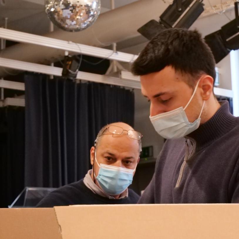 Ahmad S. und sein Sohn helfen beim Sortieren von Sachspenden.