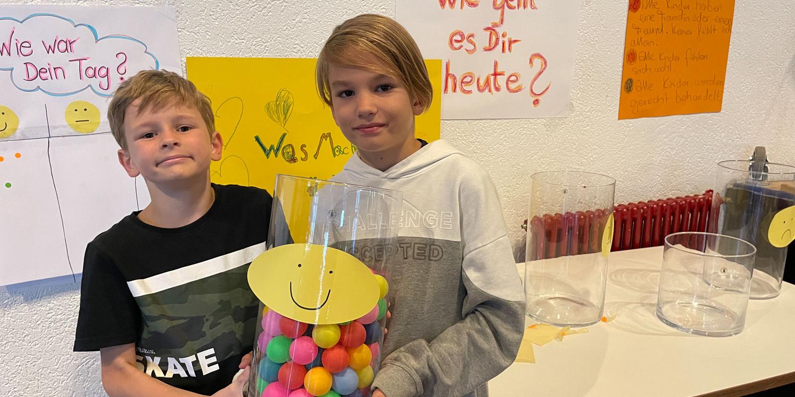 v.l. Vince und Alleen (9) zeigen, wie gut es den jungen Bewohnerinnen und Bewohnern in der Kinderstadt geht. Das zeigen die Pänz durch die bunten Bälle.