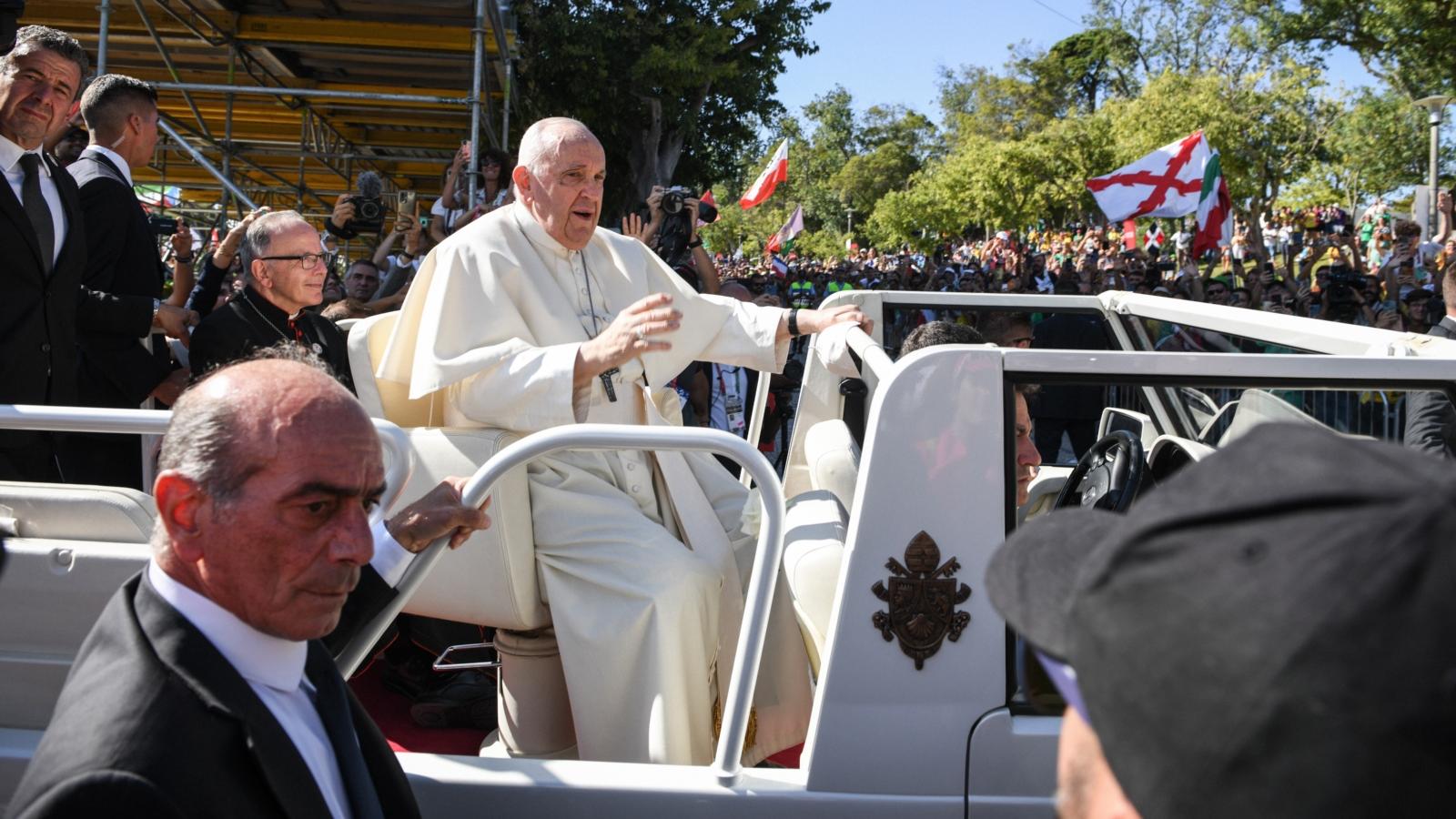 Papst Franziskus grüßt die Menschen, während er im Papamobil zum Papstwillkommen auf dem Weltjugendtag in den Parque Eduardo VII. fährt, am 3. August 2023 in Lissabon (Portugal).