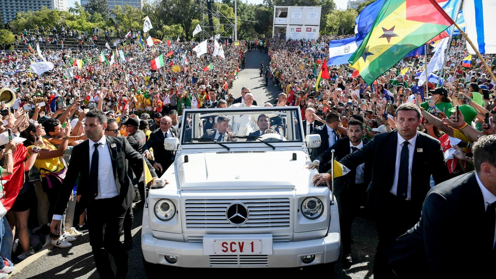 Papst Franziskus grüßt die Menschen, während er im Papamobil zum Kreuzweg auf dem Weltjugendtag in den Parque Eduardo VII. fährt, am 4. August 2023 in Lissabon (Portugal).