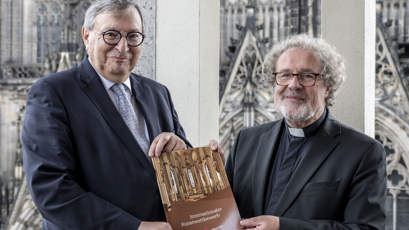 Abraham Lehrer (links) und Weihbischof Rolf Steinhäuser (rechts) präsentieren die Ausschreibung des Internationalen Kunstwettbewerbs.