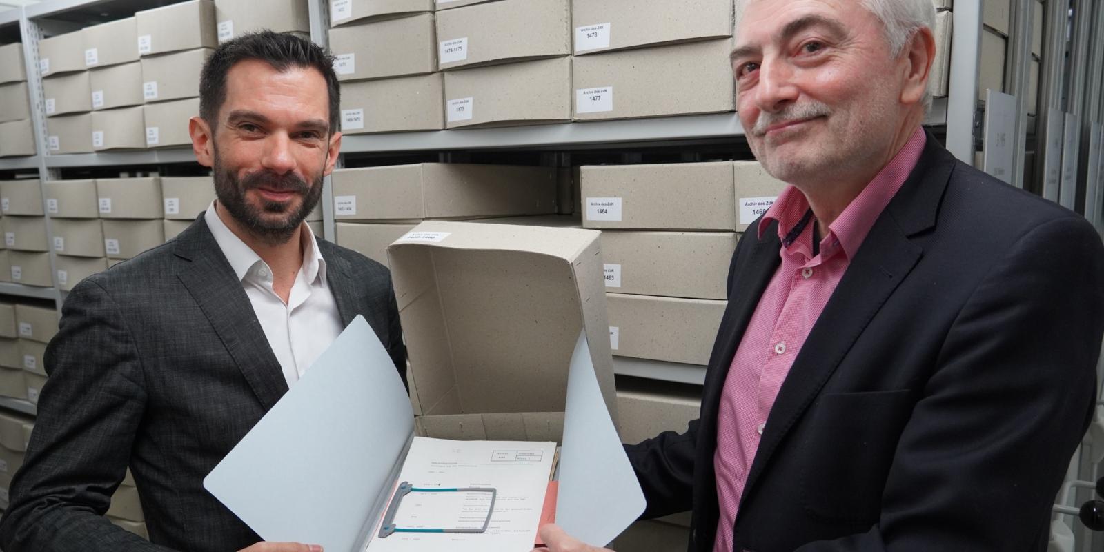 Marc Frings (Generalsekretär ZdK, links im Bild) und Dr. Ulrich Helbach (Leiter Historisches Archiv des Erzbistums Köln, rechts im Bild) präsentieren ZdK-Schriftgut, das nun in Köln lagert.