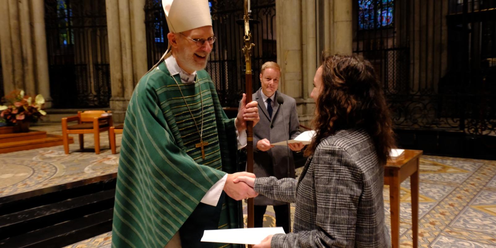 Verleihung der Missio canonica am 31.10.2023 Eine Religionslehrerin erhält Glückwünsche und die Urkunde der 'Missio canonica' von Weihbischof Ansgar Puff. Im Hintergrund: Thomas Pitsch, Bereichsleiter Schule & Hochschule im Erzbischöflichen Generalvikariat.