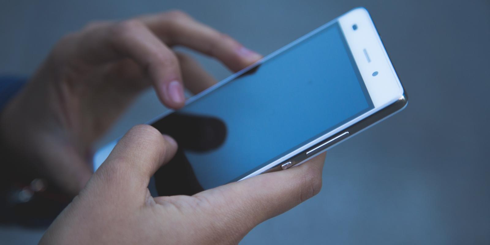 Eine Person hält ein Smartphone in den Händen.