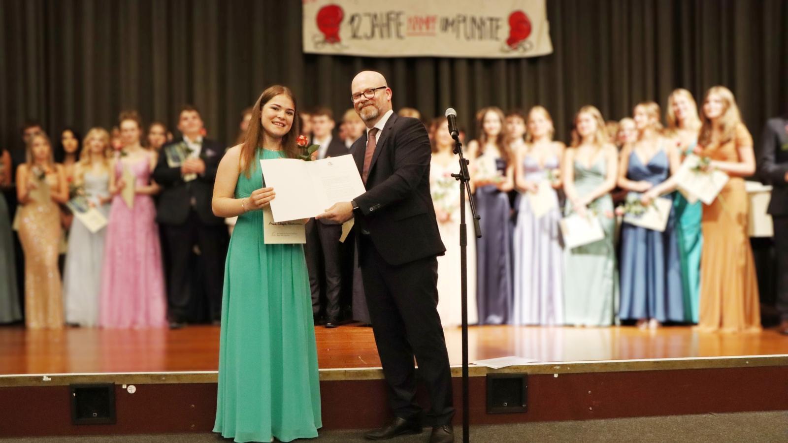 Anna Skafte-Rasmussen, Abiturientin am Erzbischöflichen Clara-Fey-Gymnasium Bonn, erhält für ihre Leistungen im 4. Fach den Abiturpreis ‚Katholische Religion‘. Die Verleihung durch den Schulleiter Christoph Dahmen hat am Freitag, 21. Juni 2024, im Rahmen der Abiturfeier und Zeugnisverleihung stattgefunden.