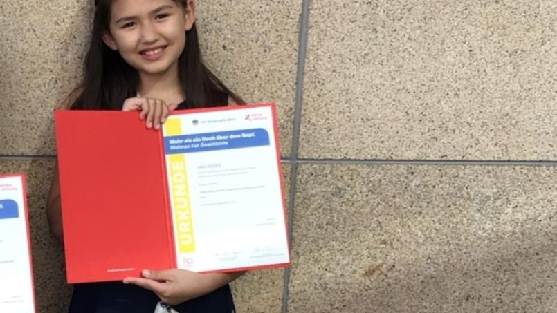 Ein Foto zeigt Lina Heider mit einer Urkunde in der Hand.