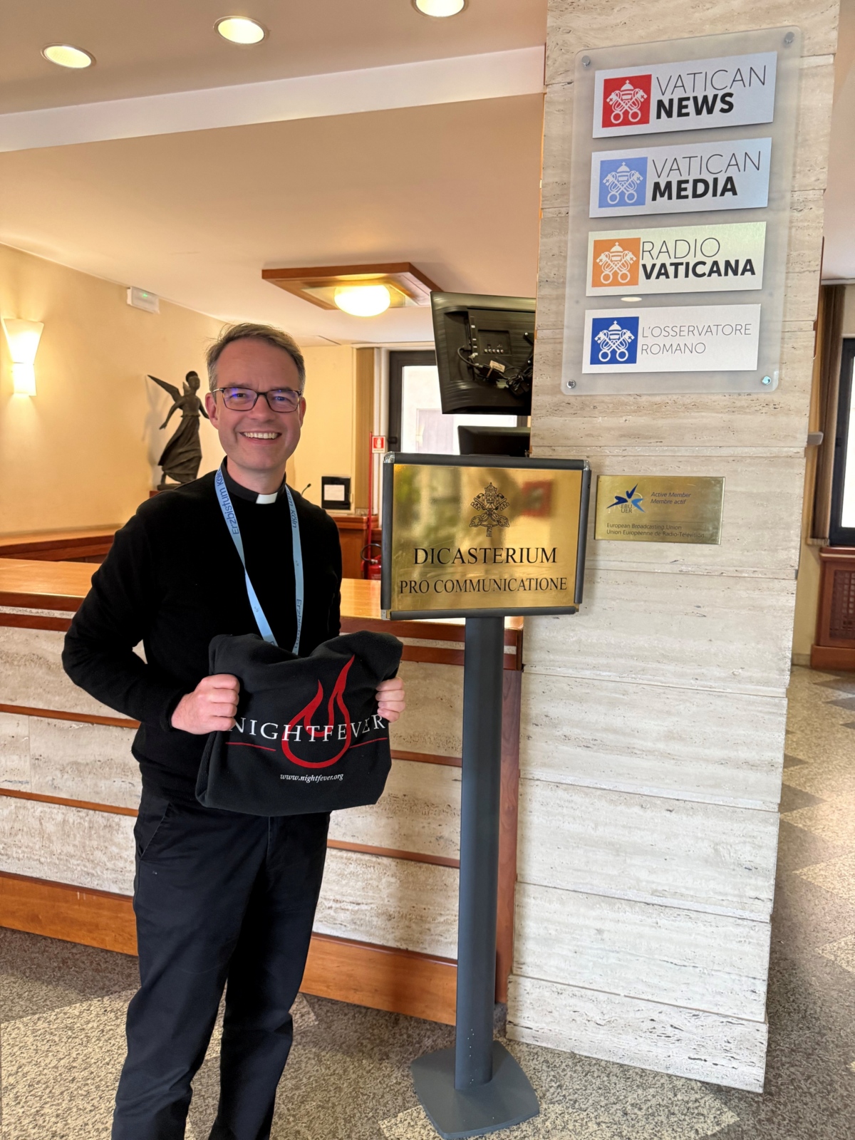 Foto von Pfarrer Andreas Süß mit dem Nightfever-Logo im Vatikan