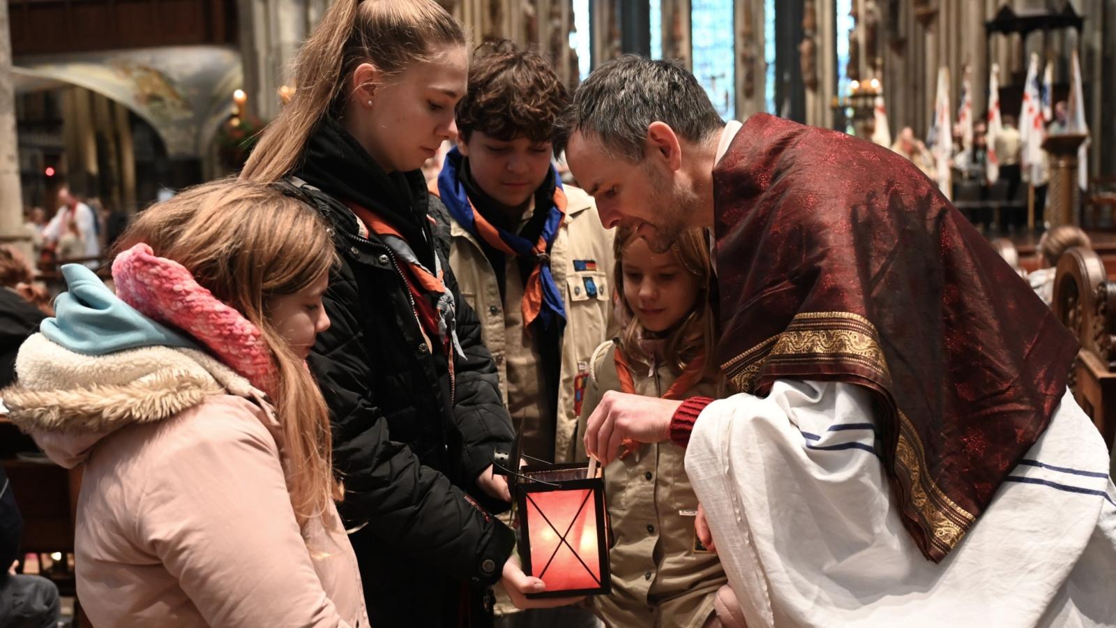Ein Foto zeigt fünf Personen. Von oben schauen sie in eine Handlaterne.