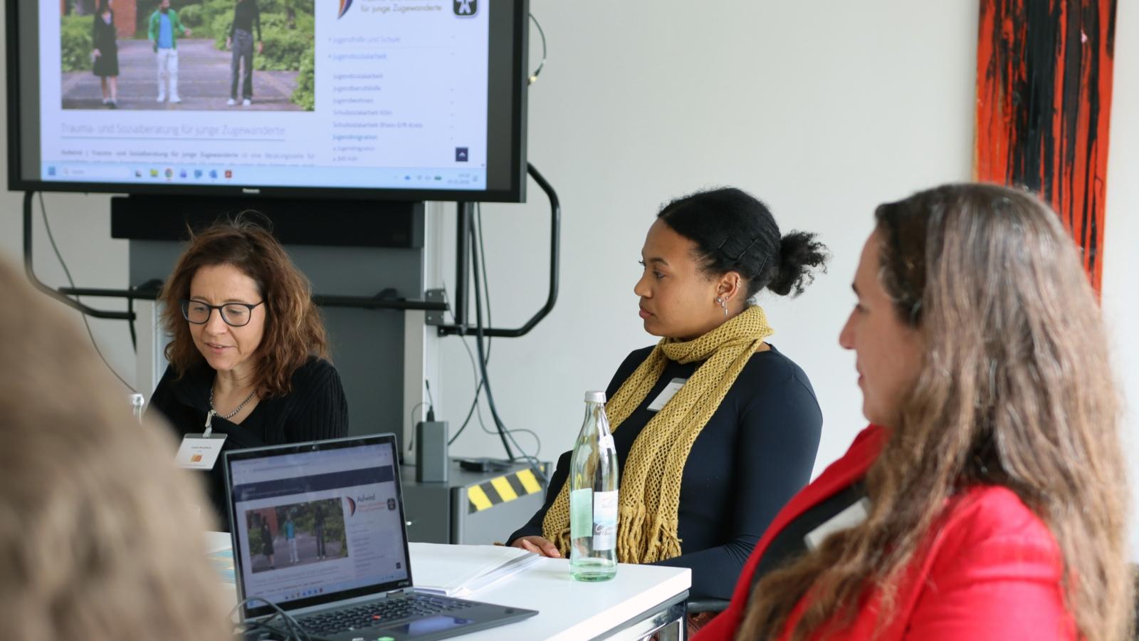 Linda Bruchholz, Michelle Mayambe und Irene Porsch stellen das Projekt 'Aufwind' der Aktion Neue Nachbarn beim 10. Katholischer Flüchtlingsgipfel vor.