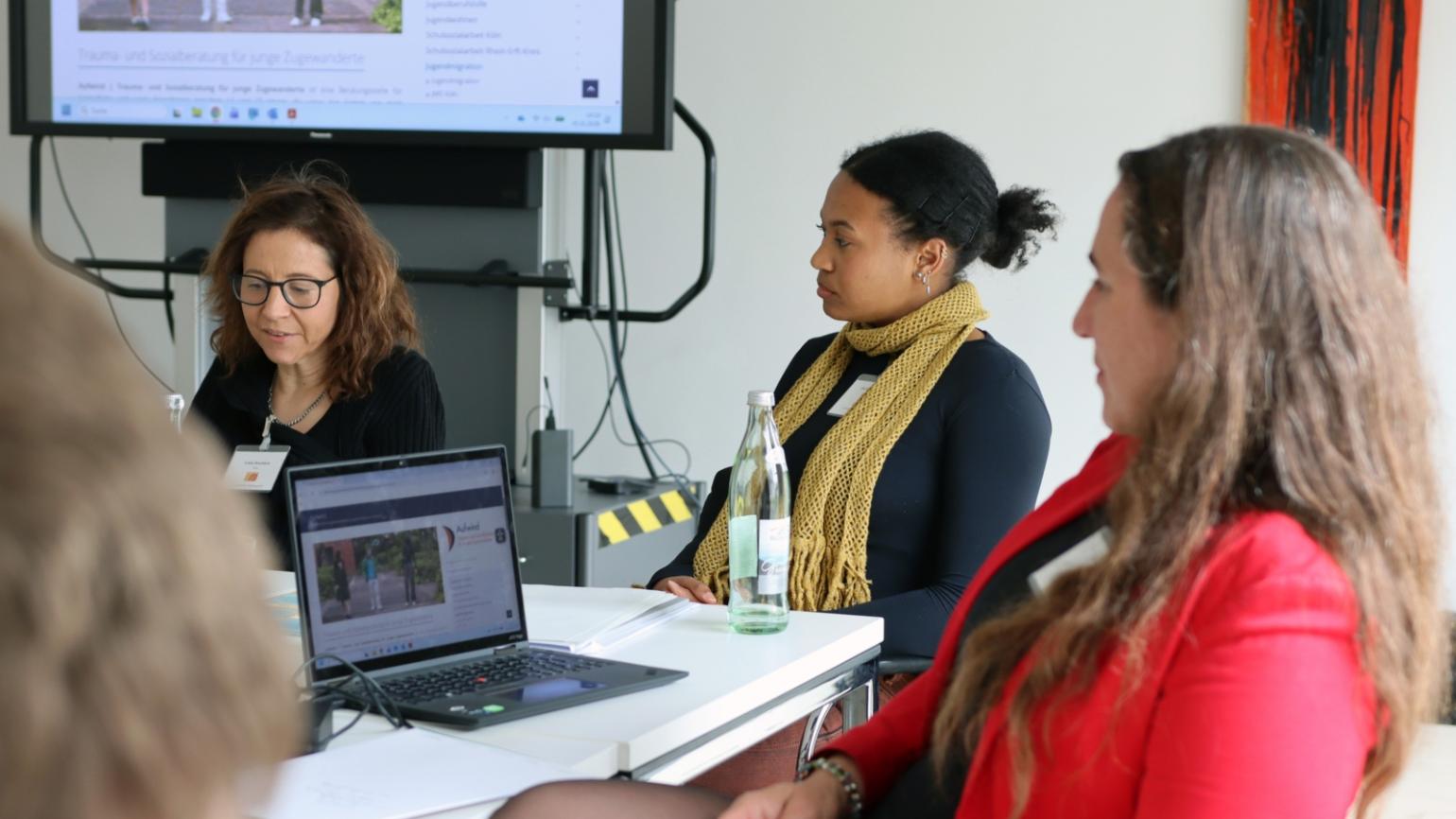 Linda Bruchholz, Michelle Mayambe und Irene Porsch stellen das Projekt 'Aufwind' der Aktion Neue Nachbarn beim 10. Katholischer Flüchtlingsgipfel vor.