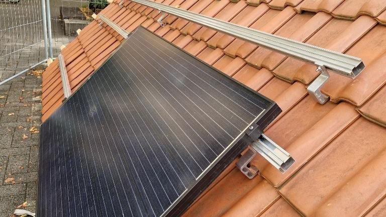 Ein Foto zeigt das Modul einer Photovoltaik-Anlage auf einem Modelldach.