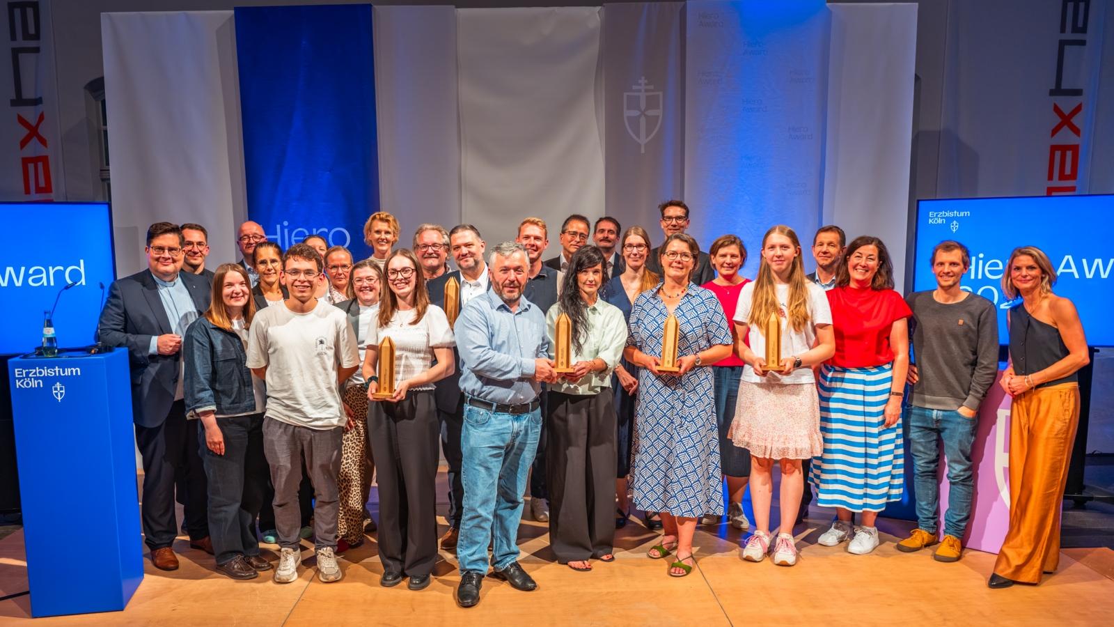 Preisverleihung zum Hiero Award 2026 am 30. September 2026 im Maxhaus in Düsseldorf, die Preisträgerinnen und Preisträger gemeinsam auf der Bühne mit der Jury, den Laudatoren, Generalvikar Tobias Hopmann, Amtsleiter Frank Hüppelshäuser und Moderatorin Anja Backhaus