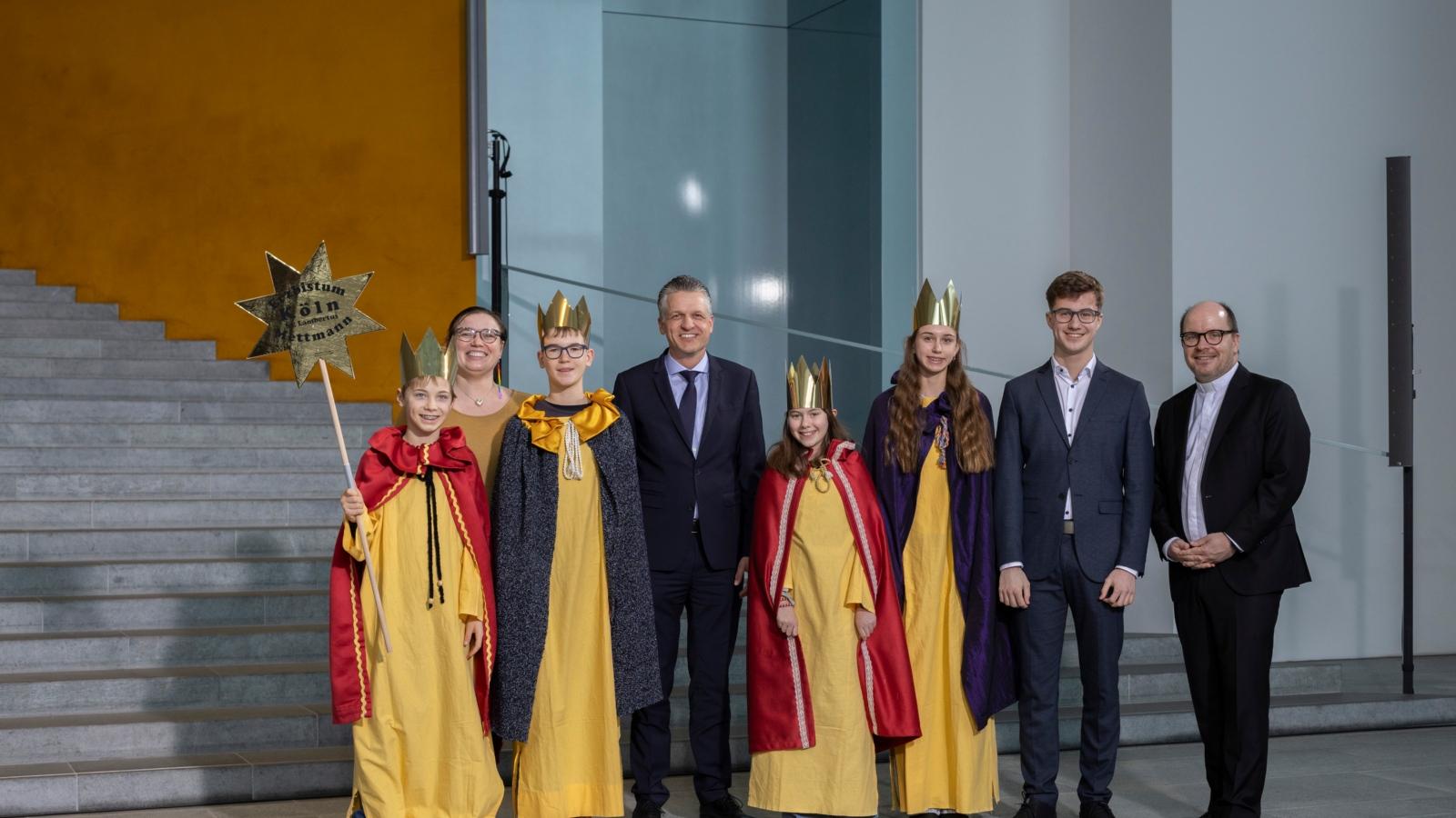 Die Sternsingerinnen und Sternsinger Kim (14), Julia (11), Julius (14) und Mirek (12) sowie Begleiter Maximilian Zygmunt aus der Pfarrgemeinde St. Lambertus in Mettmann vertraten das Erzbistum Köln am Dienstagnachmittag beim Sternsingerempfang zur 68. Aktion Dreikönigssingen im Bundeskanzleramt. Zum Gruppenfoto mit Thorsten Frei, Chef des Bundeskanzleramts, stellten sie sich gemeinsam auf mit Pfarrer Dirk Bingener, Präsident des Kindermissionswerks ‚Die Sternsinger‘, und Daniela Hottenbacher, Bundesvorsitzende des Bundes der Deutschen Katholischen Jugend (BDKJ).