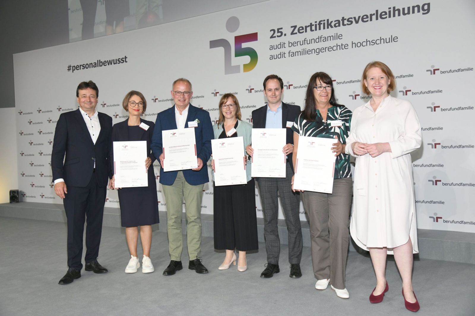 Zertifikatsverleihung 2023: Lisa Paus, MdB (Bundesministerin für Familie, Senioren, Frauen und Jugend -rechts im Bild-) und Oliver Schmitz (Geschäftsführer der berufundfamilie Service GmbH  -links im Bild-) haben am 13. Juni 2023 die neue Zertifikatsurkunde an Wolfgang Schnichels (Referent im Fachbereich Gesundheitsmanagement -3. von links-) überreicht.