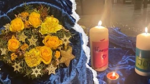 Blumengesteck und für die verstorbenen Kinder gestaltete Kerzen