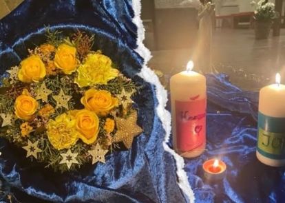 Blumengesteck und für die verstorbenen Kinder gestaltete Kerzen