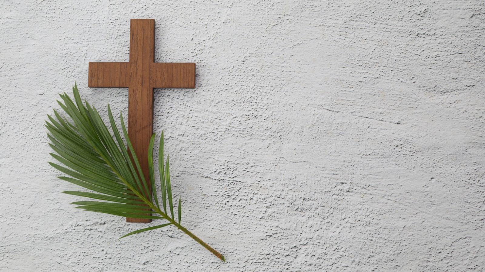 Holzkreuz auf weiss verputzter Wand mit Tannenzweig shutterstock.com vetre