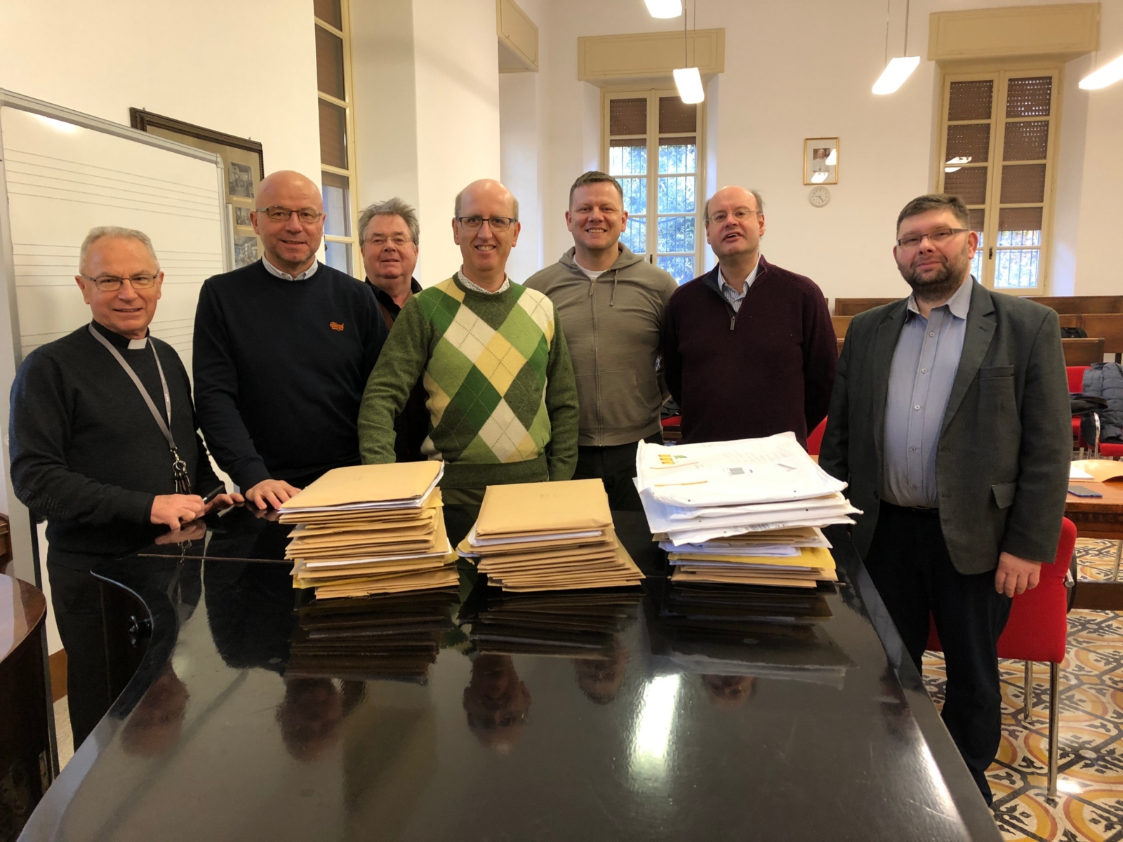 Die Jury (das obige Bild zeigt die Mitglieder vor dem Öffnen der Umschläge im päpstlichen Institut für Kirchenmusik von links nach rechts: Msgr. Vincenzo de Gregorio (Rom), Prof. Vaclovas Augustinas (Vilnius), Prof. Dr. Enjott Schneider (München), Dr. Andrea Angelini (Rimini), Eriks Esenvalds (Riga), Stephen Layton (Cambridge) und Prof. Dr. Pawel Lukaszewski (Warschau).