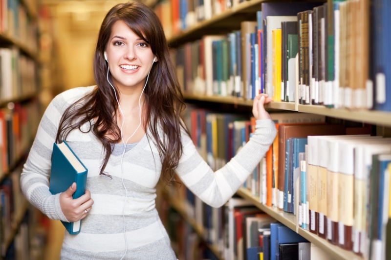 Frau am Bücherregal stehend