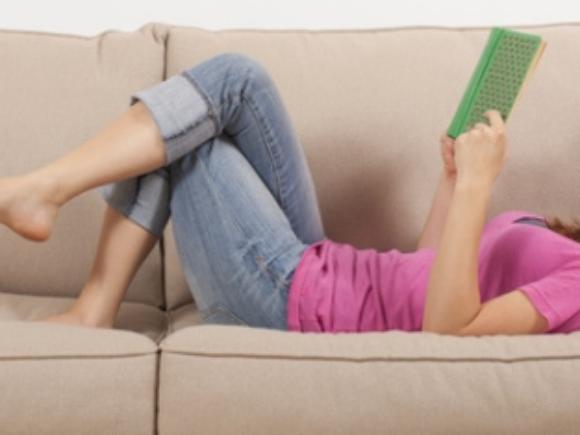 Lesende auf Sofa liegend