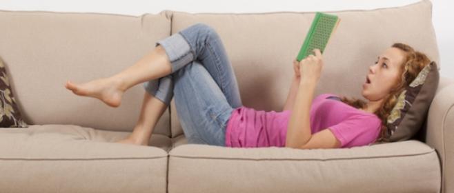 Lesende auf Sofa liegend