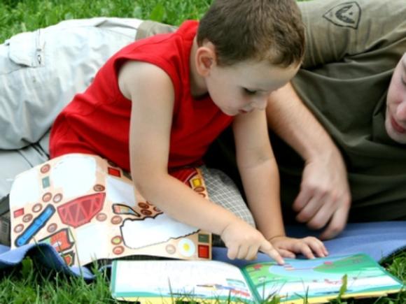 Vater und Sohn lesen auf Wiese