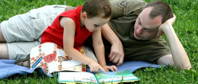 Vater und Sohn lesen auf Wiese