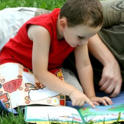 Vater und Sohn lesen auf Wiese