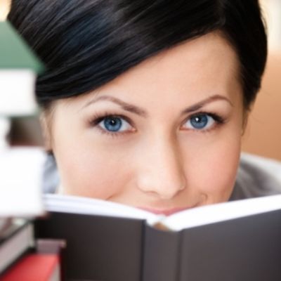 Frau hinter Bücherstapeln