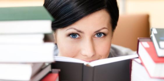 Frau hinter Bücherstapeln