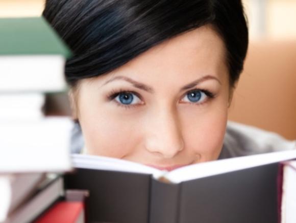 Frau hinter Bücherstapeln